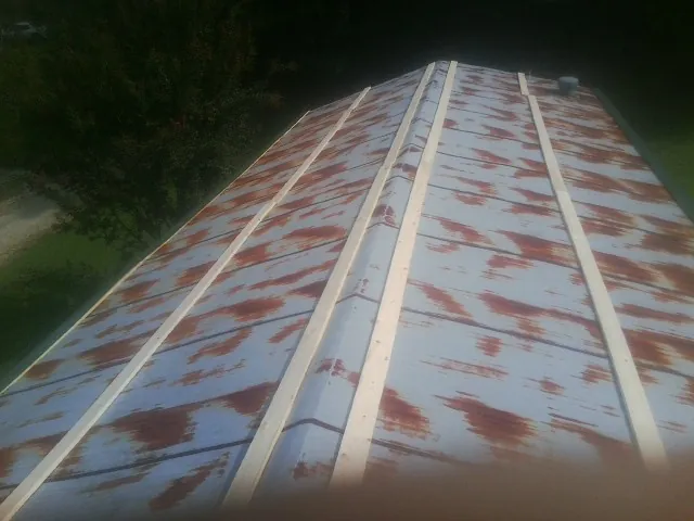 Rusted metal roof panels with new wood purlins before replacement — Storm Damage Roof Repair in Silverado by Roofing Brothers