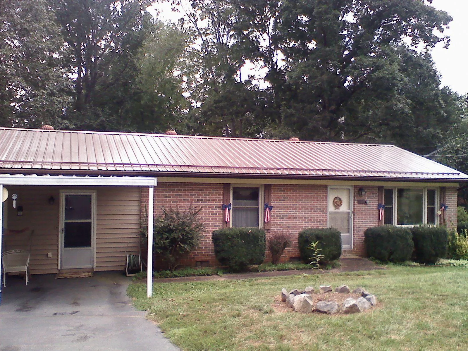 Bronze metal roof and carport on a brick ranch home — Roof Repair work by our crew in Silverado